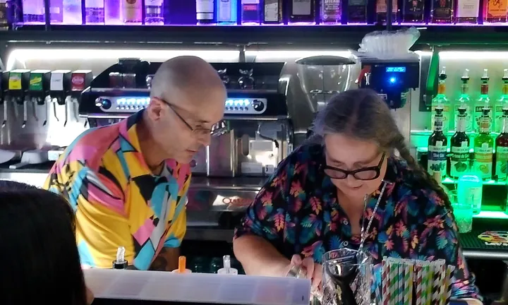 Two bartenders working together behind the bar.